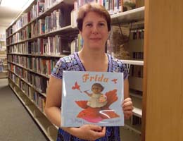 TCC librarian with a book to be sent to Guatemala