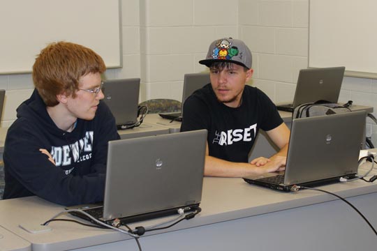 Timothy Collins and Travis Barnes share ideas in class.