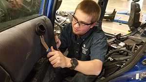 Student repairing the inside of a car door