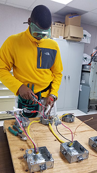 Student in safety goggles working on wiring