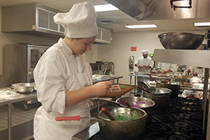 Culinary student mixes icing and decorates gingerbread