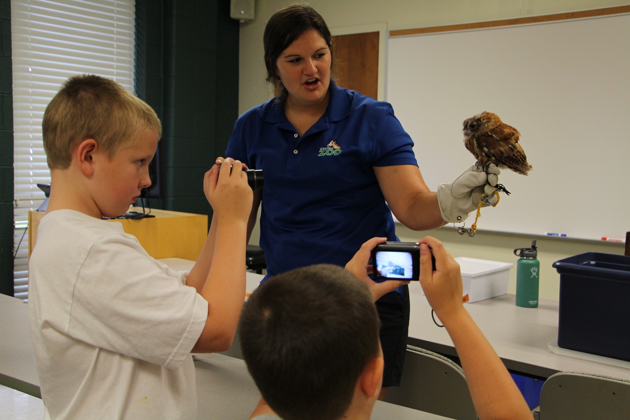 Samantha Hagedorn, with the Virginia Zoo, shows campers many species including a spotted owl.