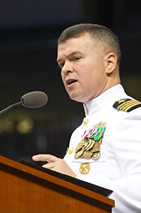 man in naval uniform speaking at podium