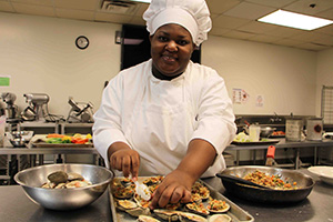 woman in chef's uniform prepares food