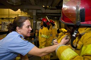 Female firefighter checks the gear of another woman