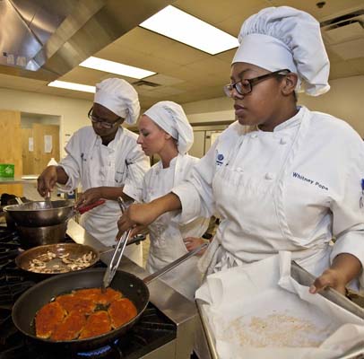 culinary students work around a stove